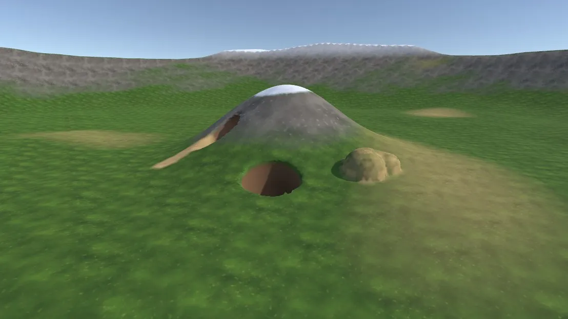 A Dig Zone on a Unity Terrain: a tunnel through a hill, a dug pit, added soil, and painted snow, rock and sand